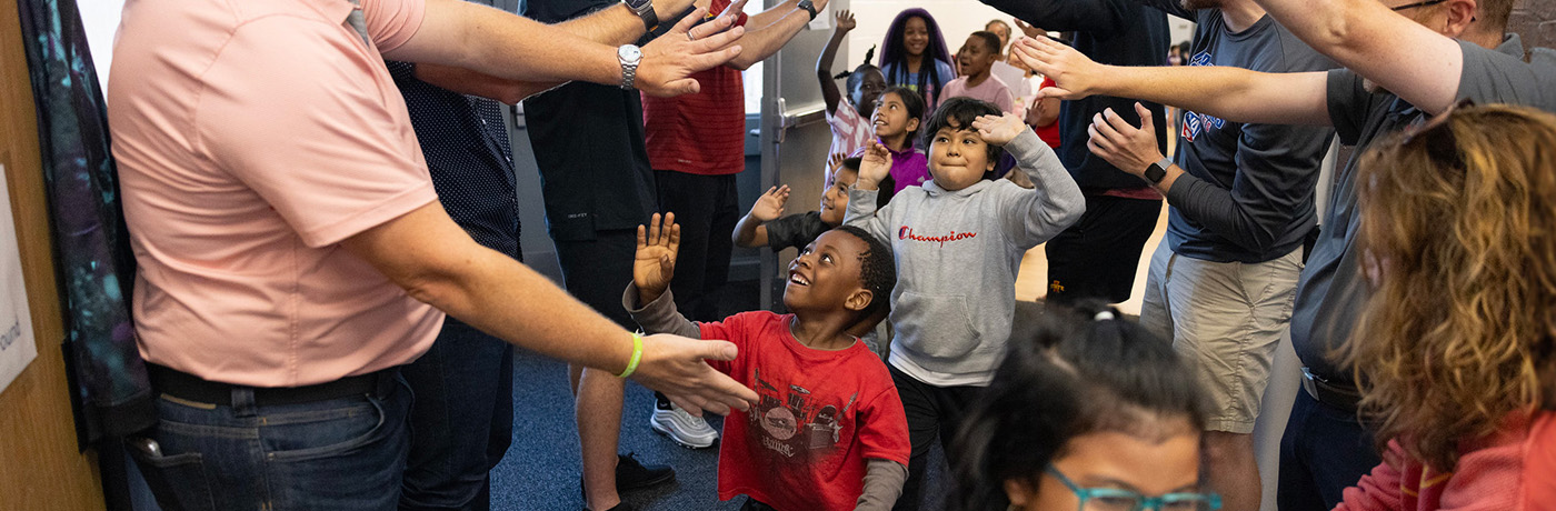 students high fiving teachers